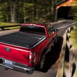 Red GMC Truck on Road with Extang Bed Cover