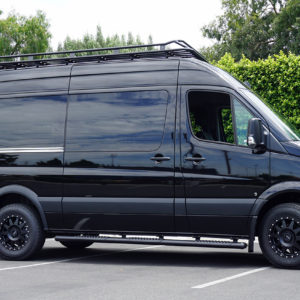 Upfitted cargo van with Rhino roof rack, AMP side steps, and grille guard.