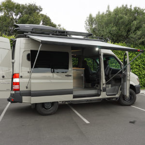 Customized Adventure and Travel Sprinter Van with Thule Cargo Box, Extended Fiamma Awning, and Custom Cabinets.