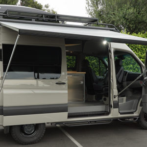 Customized Adventure and Travel Sprinter Van with Thule Cargo Box, Extended Fiamma Awning, and Custom Cabinets.
