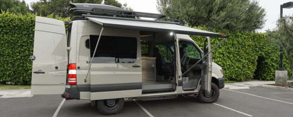 Customized Adventure and Travel Sprinter Van with Thule Cargo Box, Extended Fiamma Awning, and Custom Cabinets.