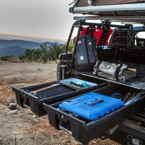 Overlanding rig with rooftop tent, open rear with DECKED drawers pulled out and adventure gear stowed.