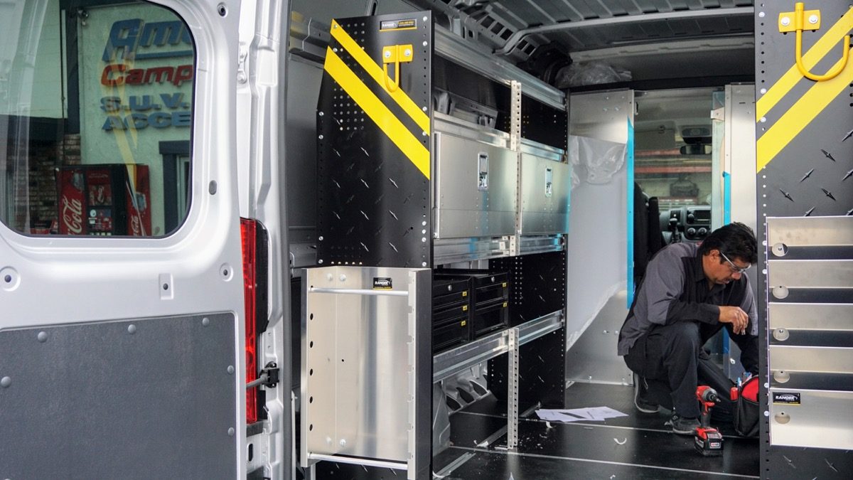 American Trucks and Vans technician installing Ranger Design shelving and partition.