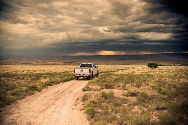 White GMC Truck on Desert Road with Extang Bed Cover