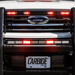 Upfitted Ford van with Whelen emergency lights in front grille.