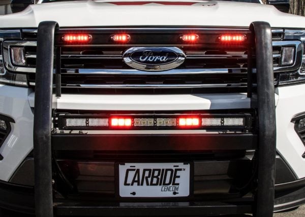 Upfitted Ford van with Whelen emergency lighting in front grille.