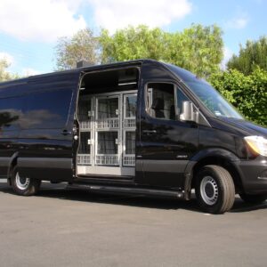 Van with open door revealing interior cages secured for mobile dog daycare and transport.