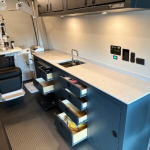 Custom cabinet and drawers inside upfitted cargo van for mobile eye clinic.
