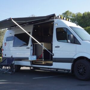 Customized Adventure and Travel Van with Mountain Bike Rack, Extended Fiamma Awning, and Refrigerator with Popup Shelf.