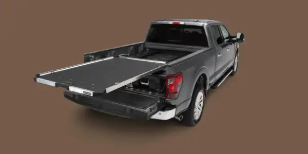 4x4 truck with DECKED CargoGlide Truck Bed System fully extended and compatible DECKED drawer system visible underneath, shown against a neutral background.