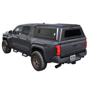 Alt: Overland Vehicle Systems truck cap installed on black Toyota Tacoma 5 foot bed