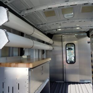 Interior of a plumbing van showing Ranger wall-mounted pipe tubes and partition.