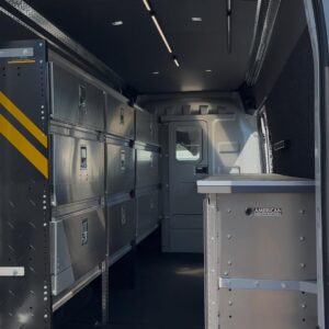 Wide interior view of locksmith van upfit showing shelving layout from rear doors