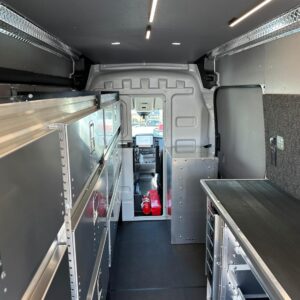 Interior view of locksmith van upfit showing partition, workbench, and storage cabinets