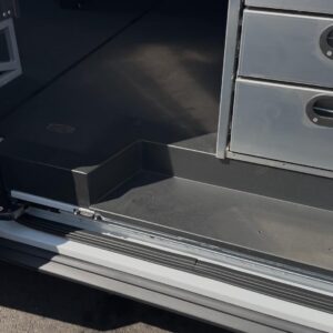 Side door sill plate in locksmith van upfit protecting entry point below shelving